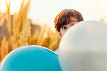 niño jugando con globos